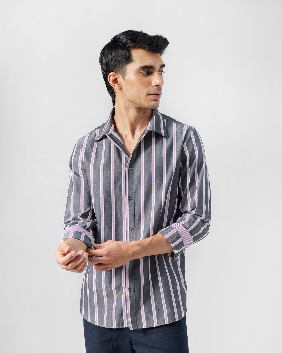 Person wearing a charcoal and pink striped Classic shirt with rolled cuffs.