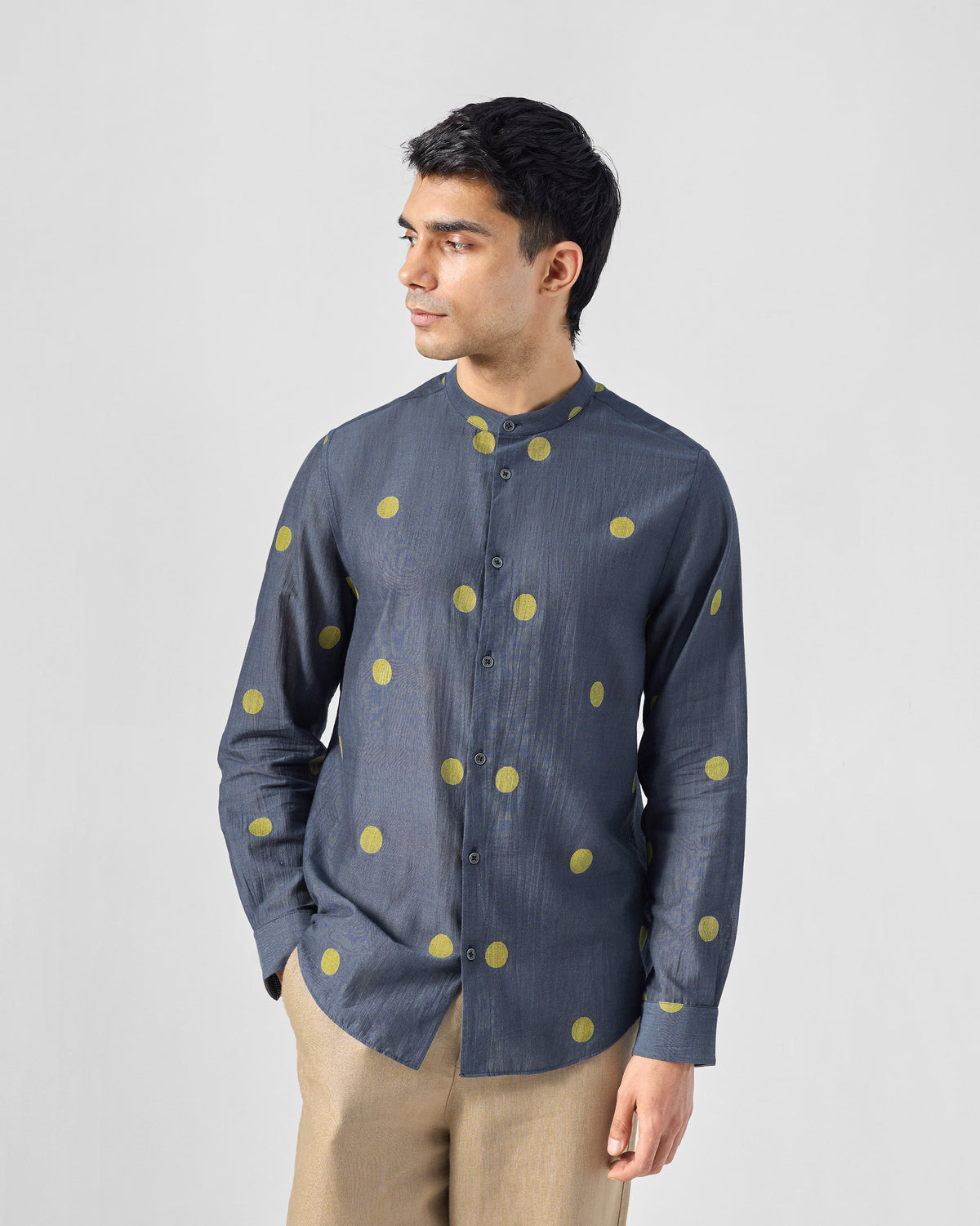 Person wearing a charcoal Nawab Shirt with a Nehru collar and chartreuse polka dots.