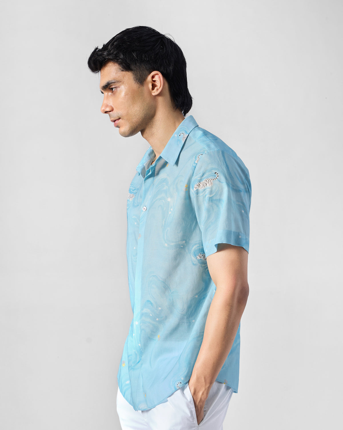 Side view of a light blue printed Riverine shirt with wave motifs.