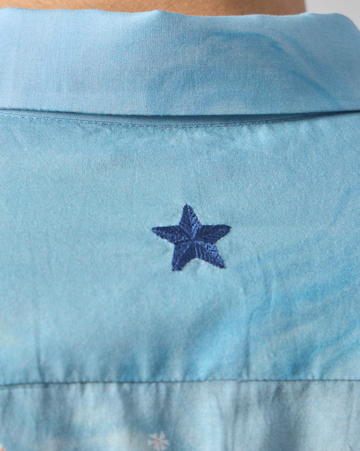 Close-up of a light blue Riverine shirt back with a navy embroidered star.