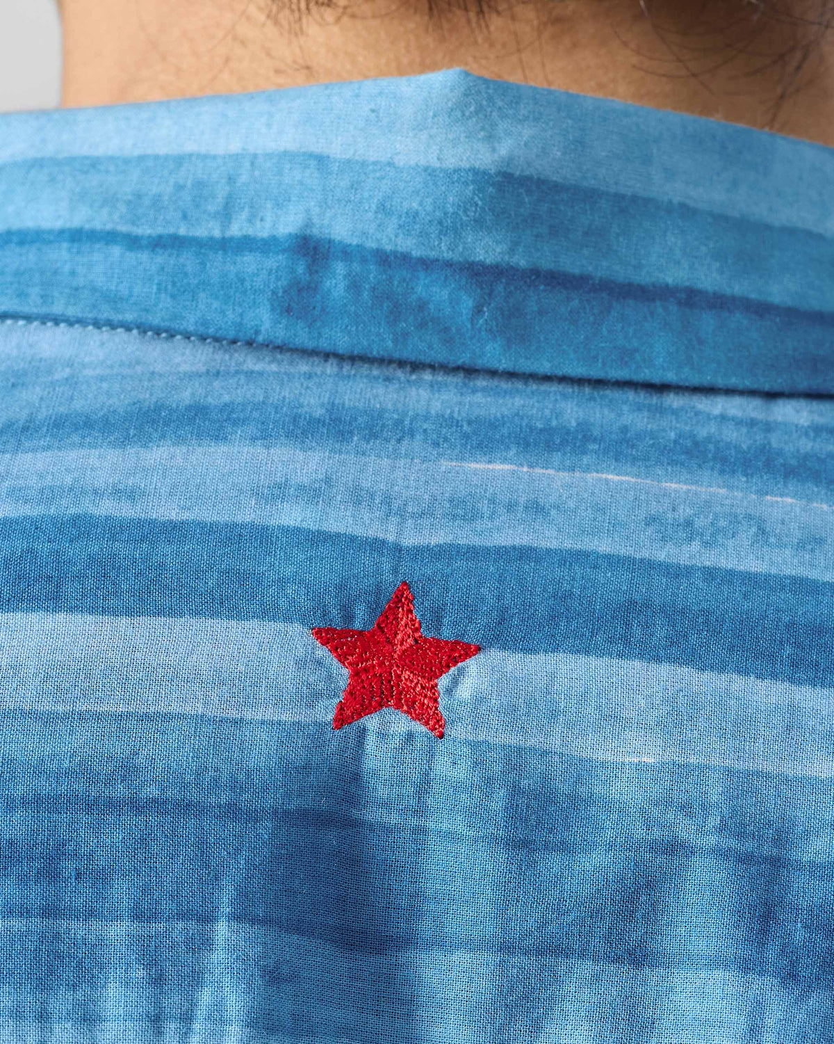 Close-up of a red star embroidery on the Ganga shirt back.