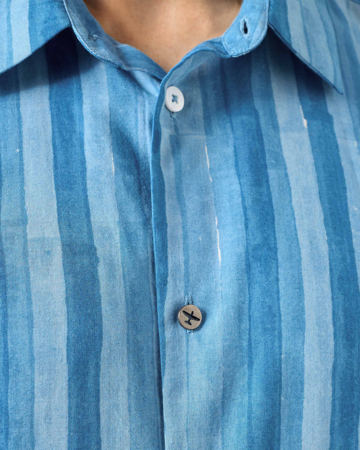 Close-up of a Ganga shirt collar showing an airplane button.
