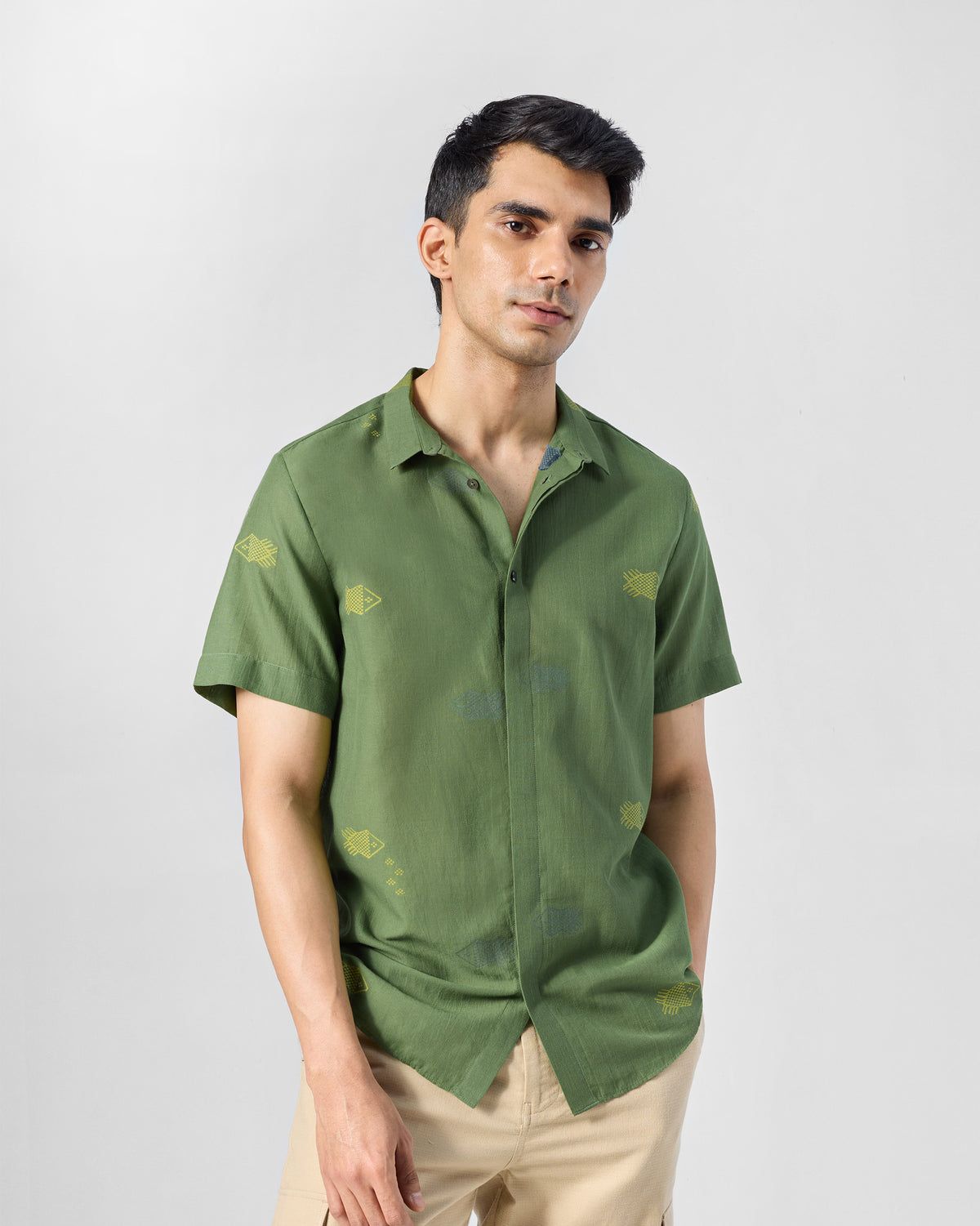 Person wearing a green Riverine shirt with yellow fish embroidery.