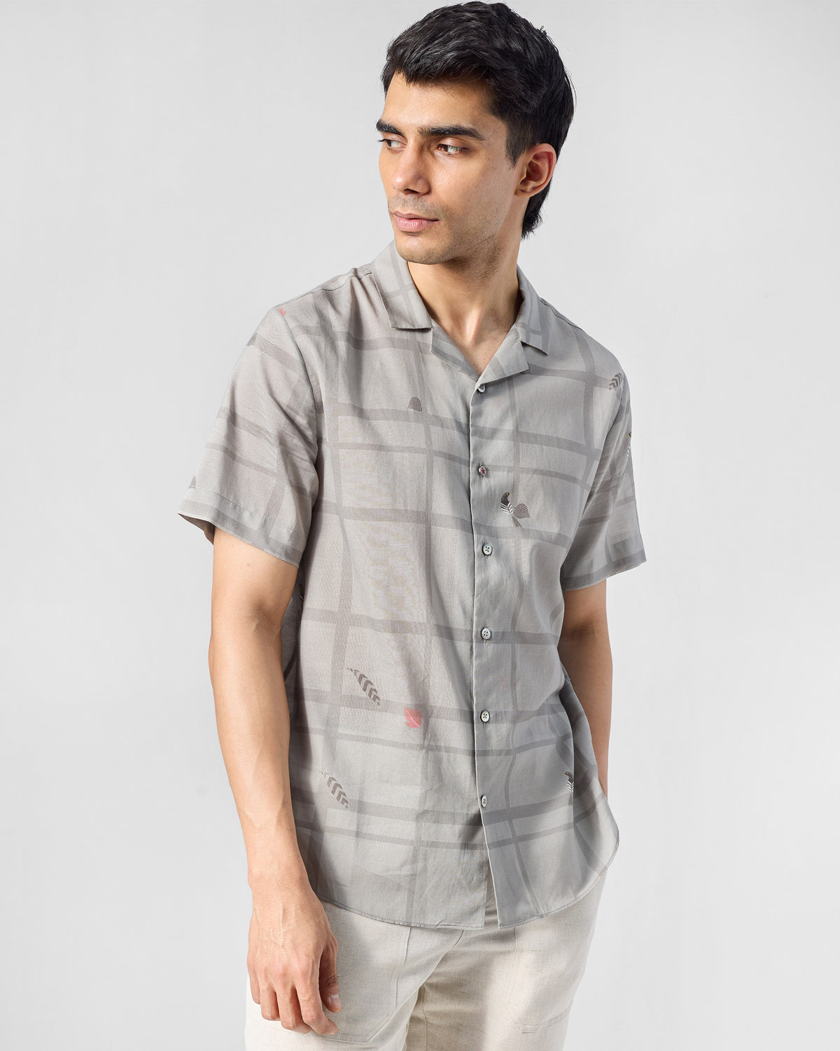 Person wearing a charcoal Mistari Shirt with a check print.