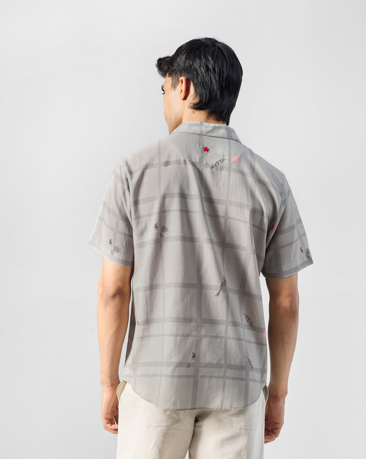 Back of a charcoal Mistari Shirt with a red star.