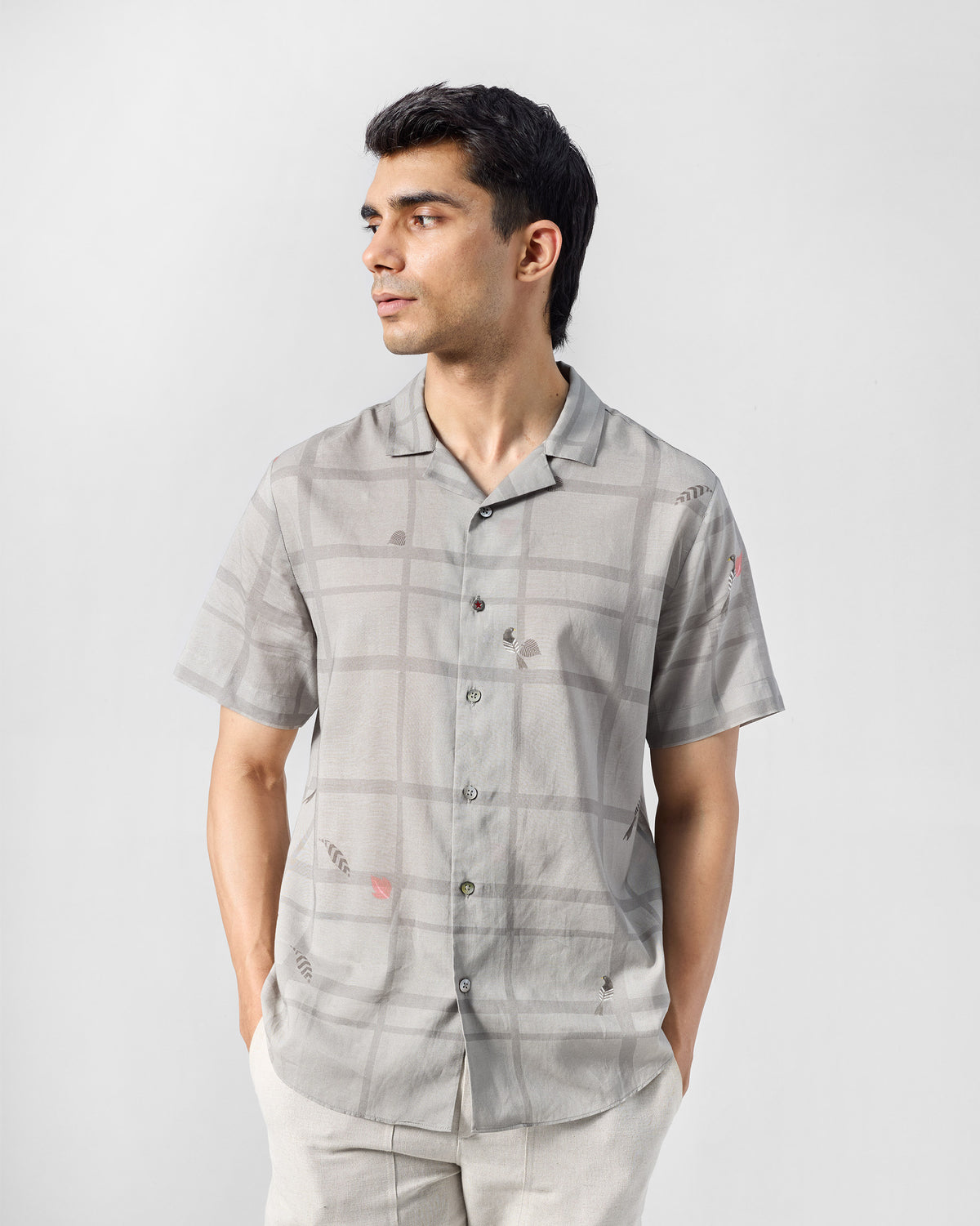 Person wearing a charcoal Mistari Shirt with a check print.