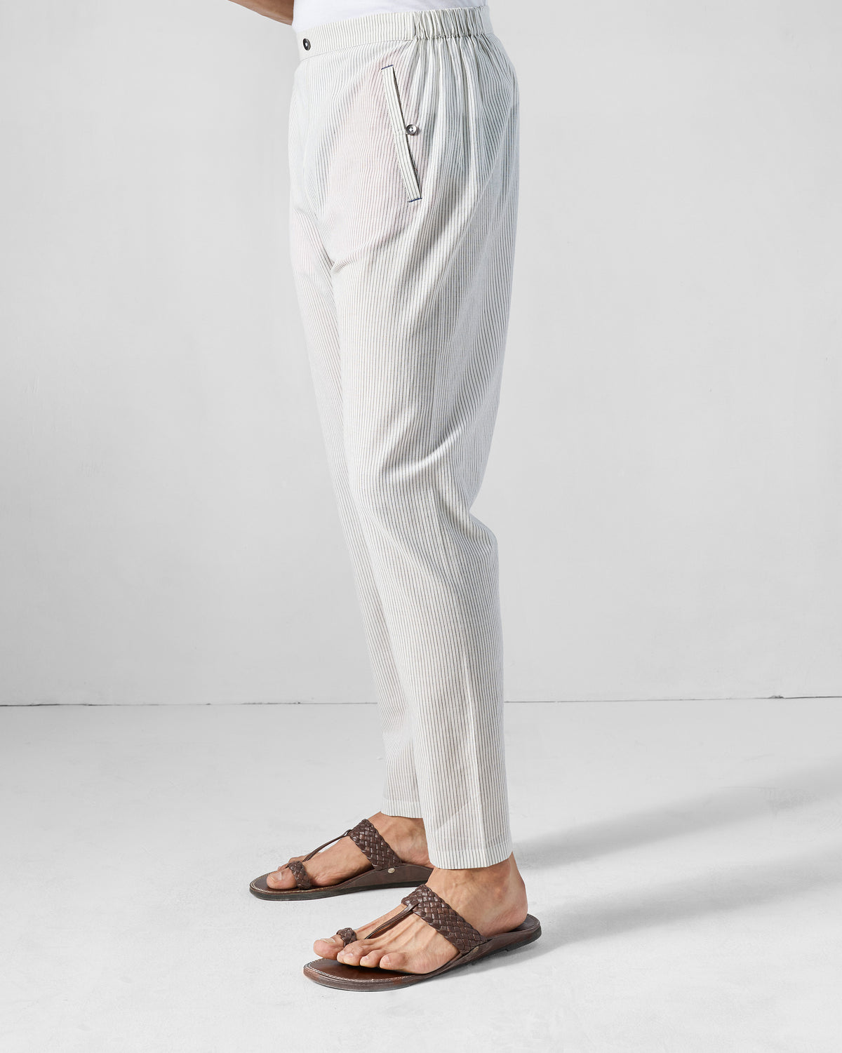 Side view of charcoal and white striped Kurta Pants with a tapered crop.