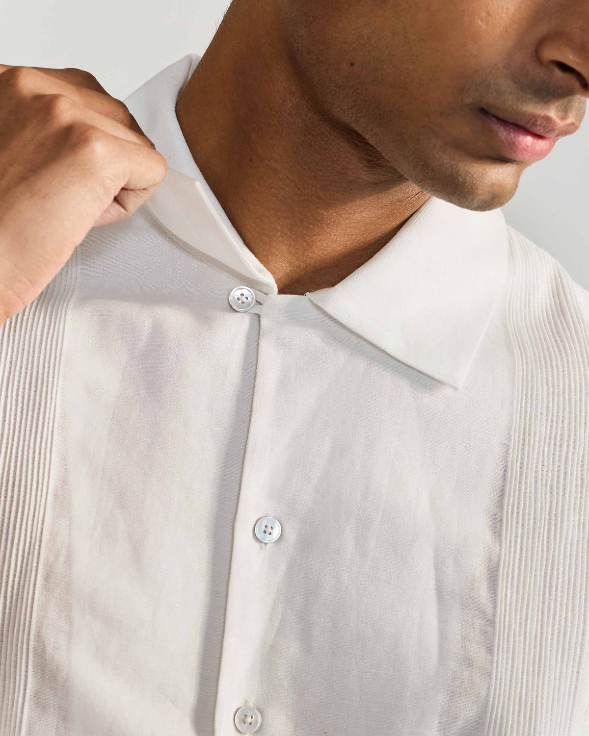 Close-up of the collar and front pintucks on a white Egret shirt.