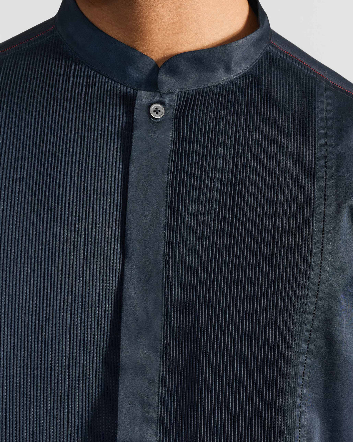 Close-up of a navy Nightjar shirt collar with dense chest pintucks.
