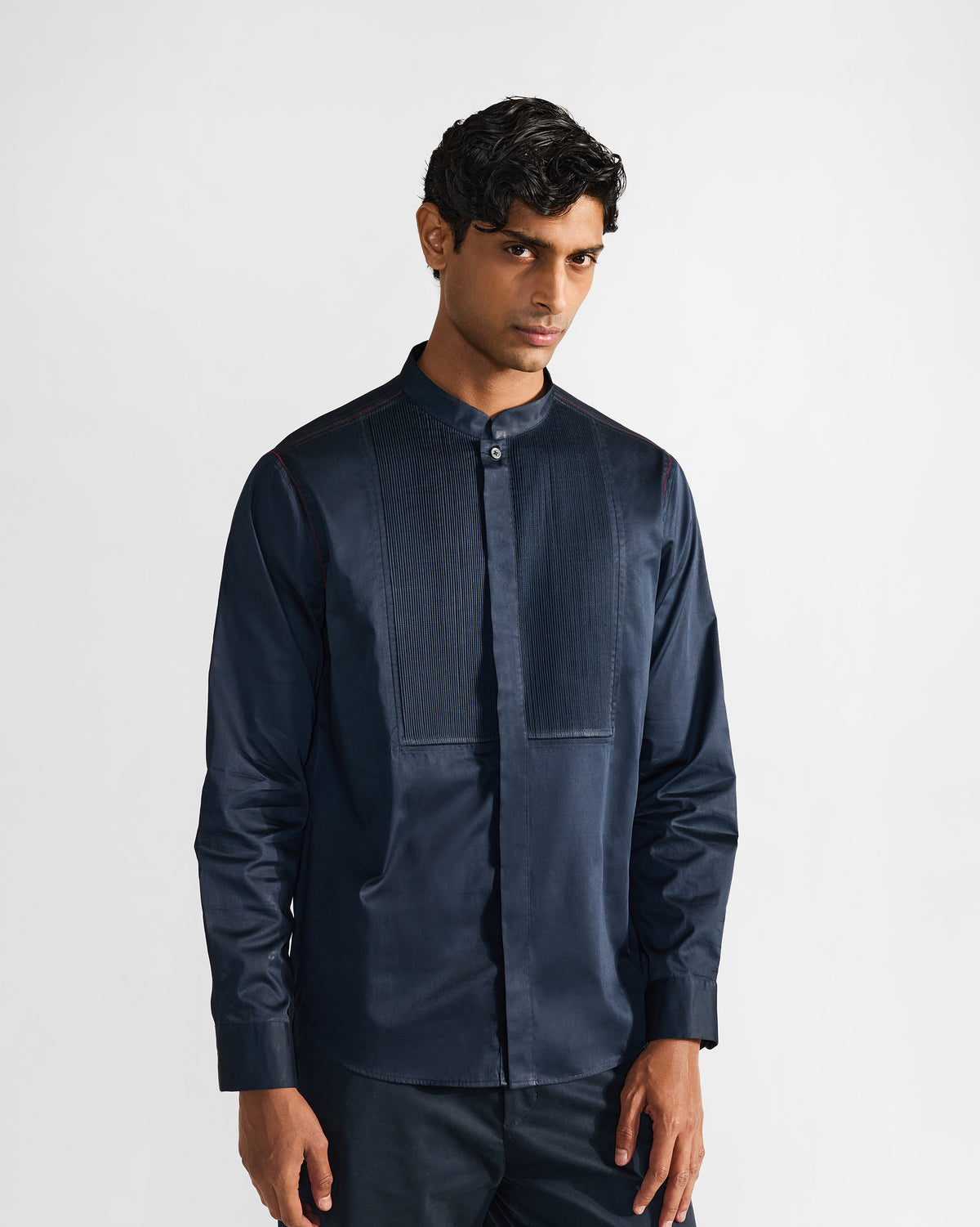 Person wearing a navy Nightjar shirt with a fine pintuck bib.