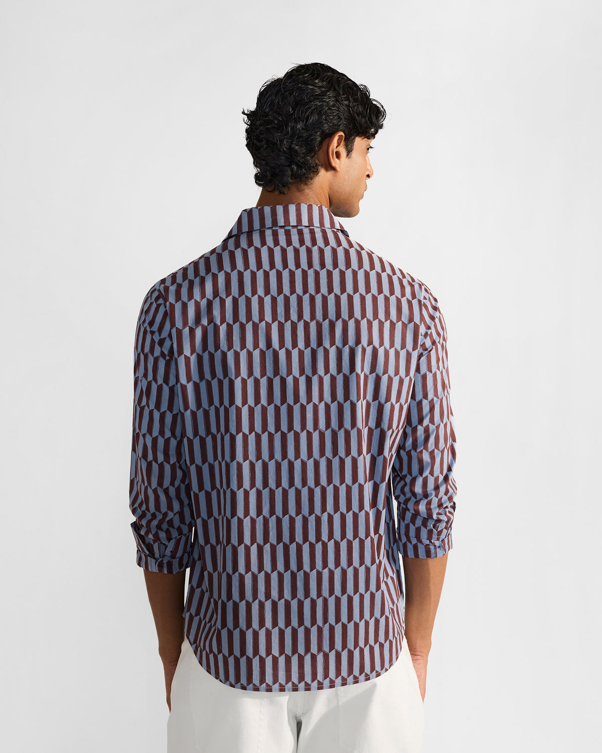 Back of a brown and light blue geometric print Drongo shirt with a curved hem.