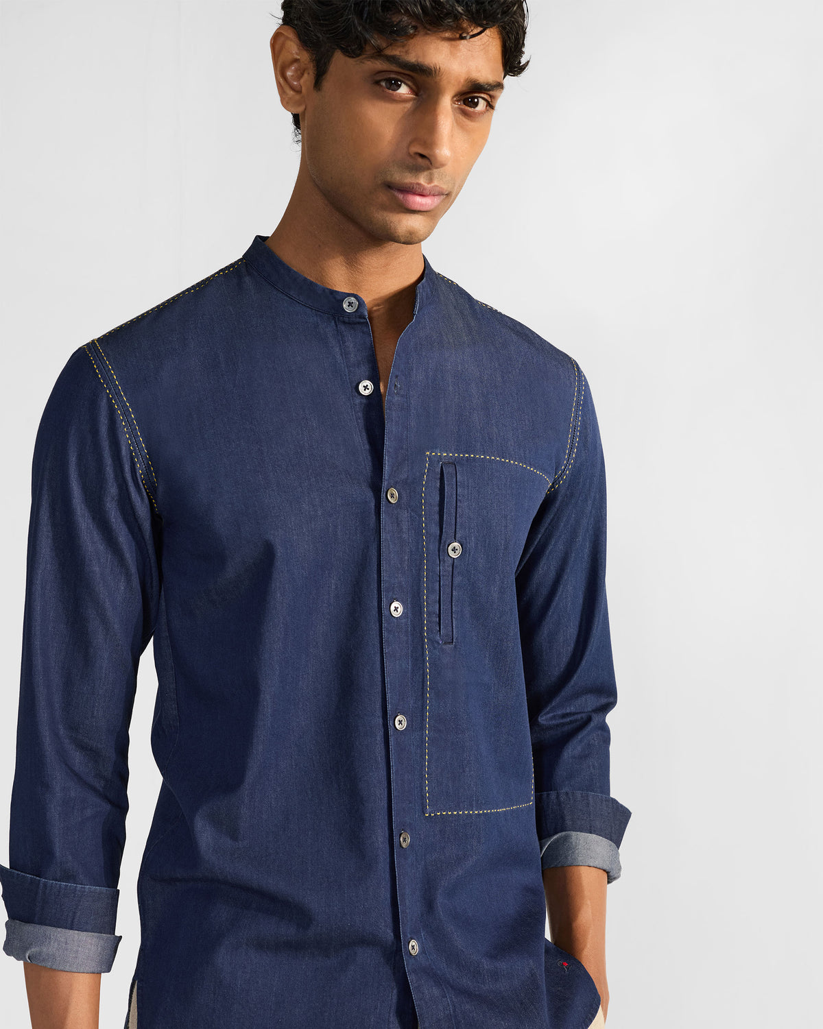 Person wearing an indigo Loris shirt with yellow topstitching.