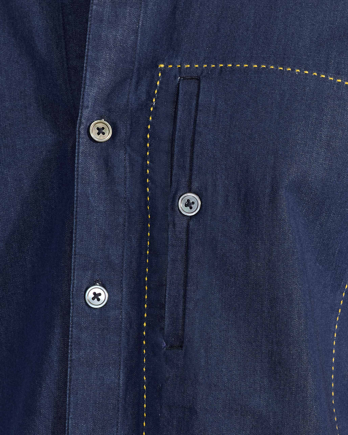 Close-up of a yellow-stitched pocket on an indigo Loris shirt.