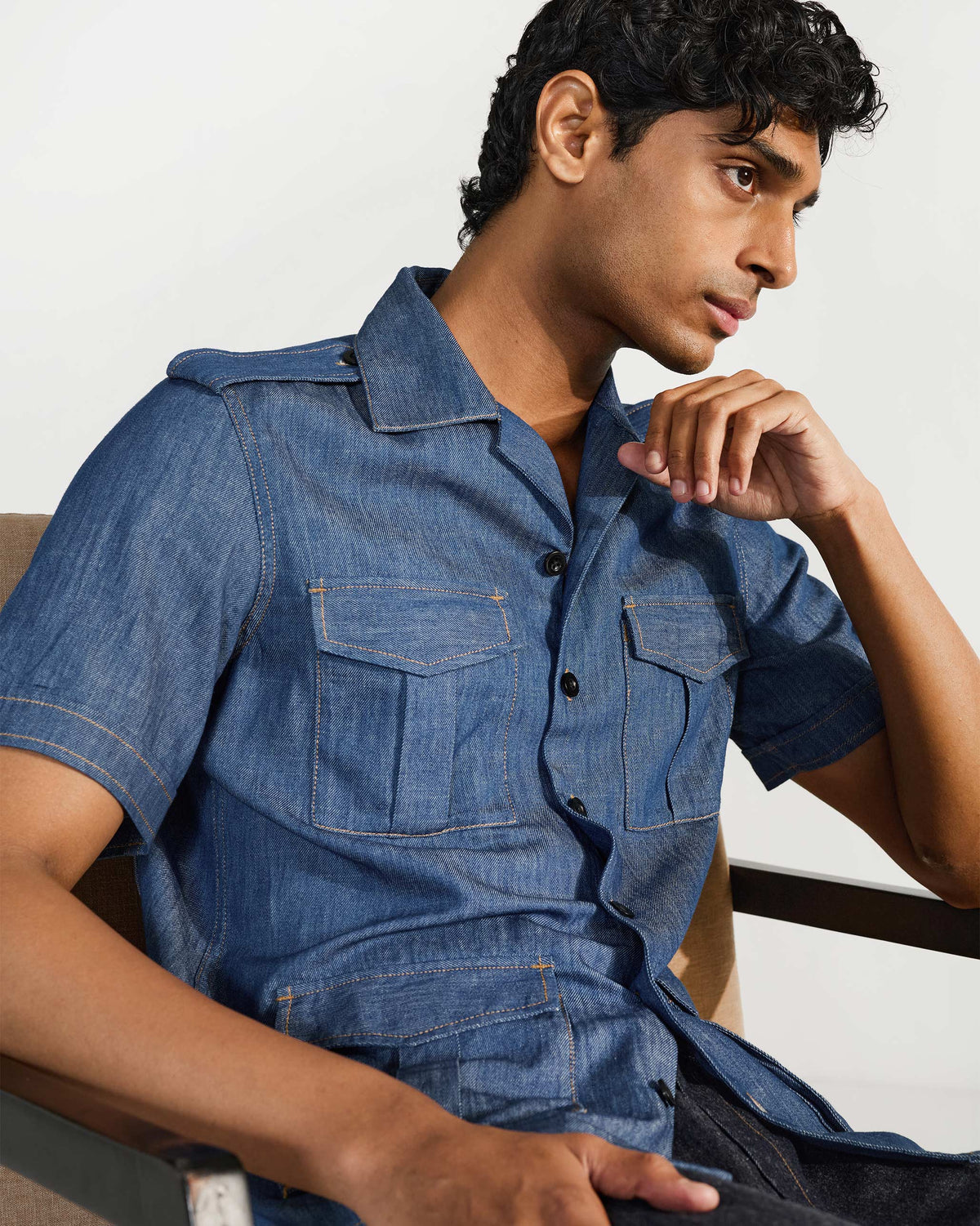 Person wearing a blue denim Sambar shacket with epaulettes and chest pockets.