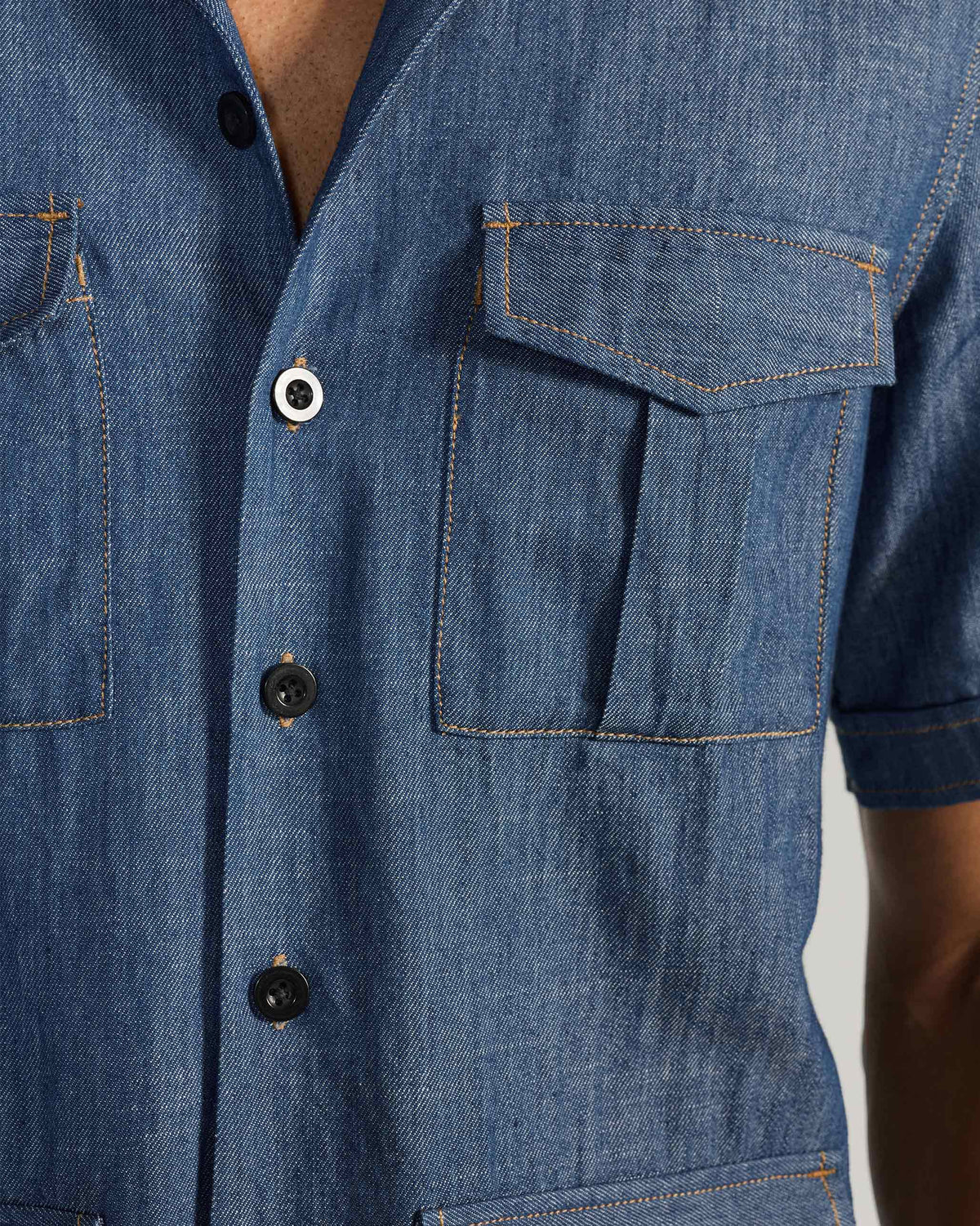 Close-up of a flapped chest pocket on a blue denim Sambar shacket.