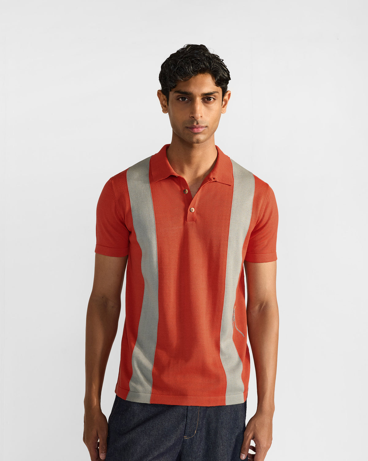 Bonnet Polo in rust orange with wide grey front stripes worn front view.