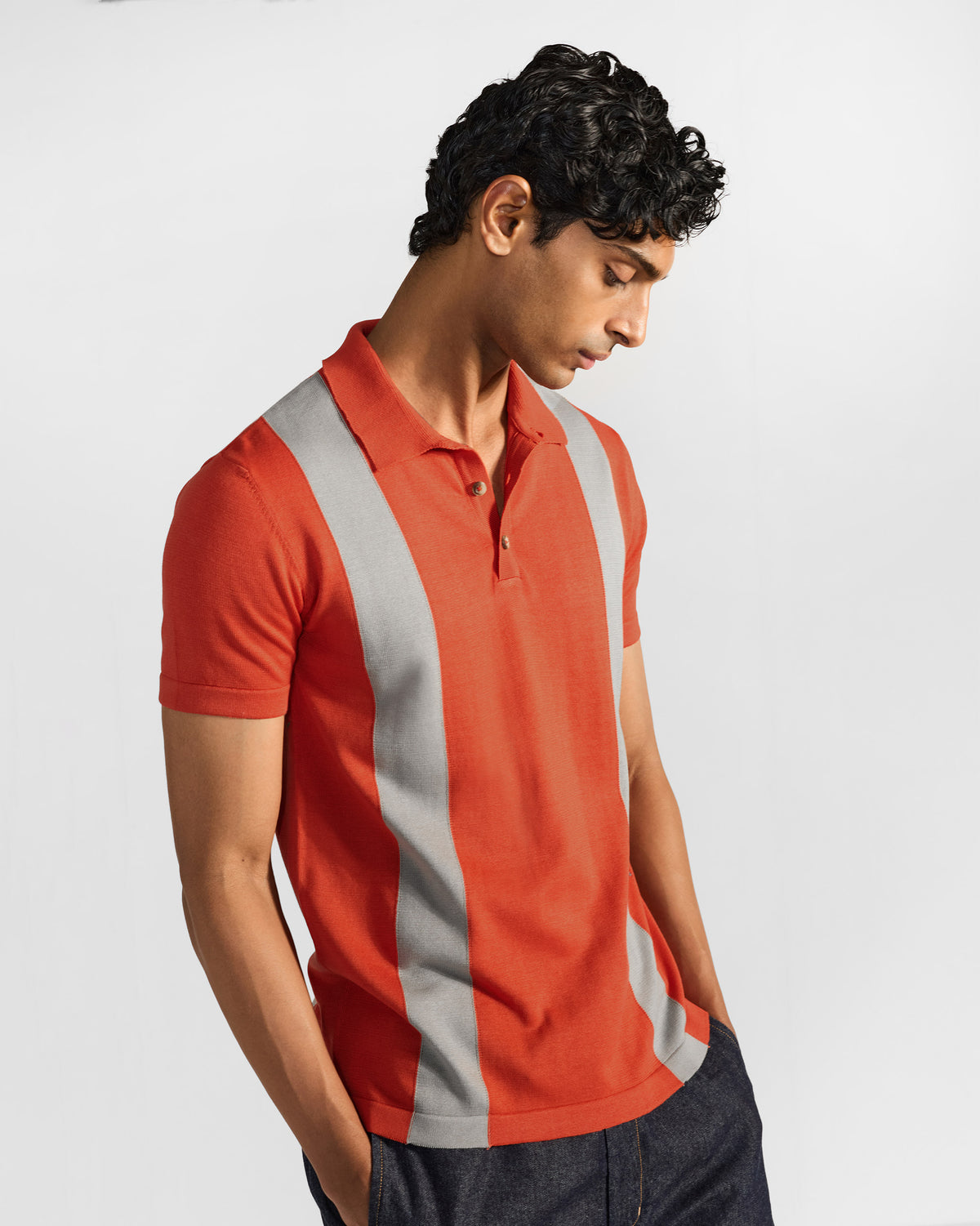 Bonnet Polo three-quarter front in rust orange with grey vertical stripes.