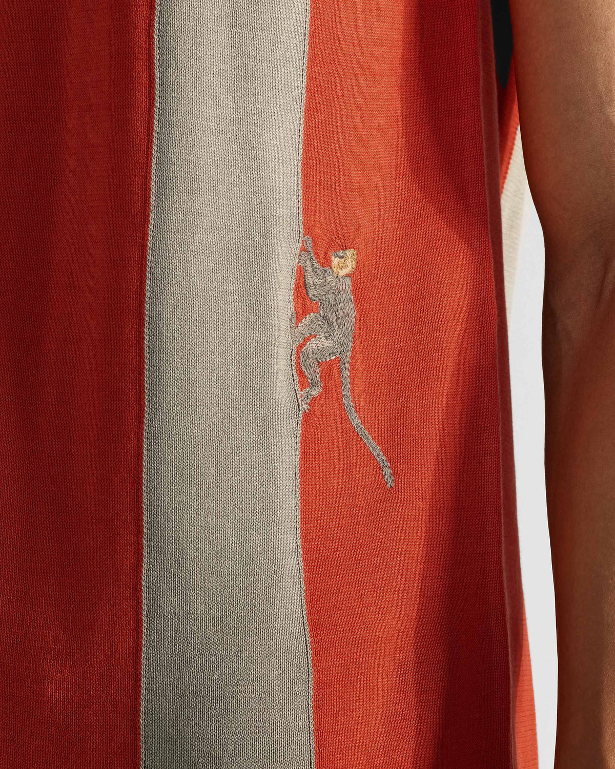 Close-up of Bonnet Polo stripe knit with embroidered climbing monkey.
