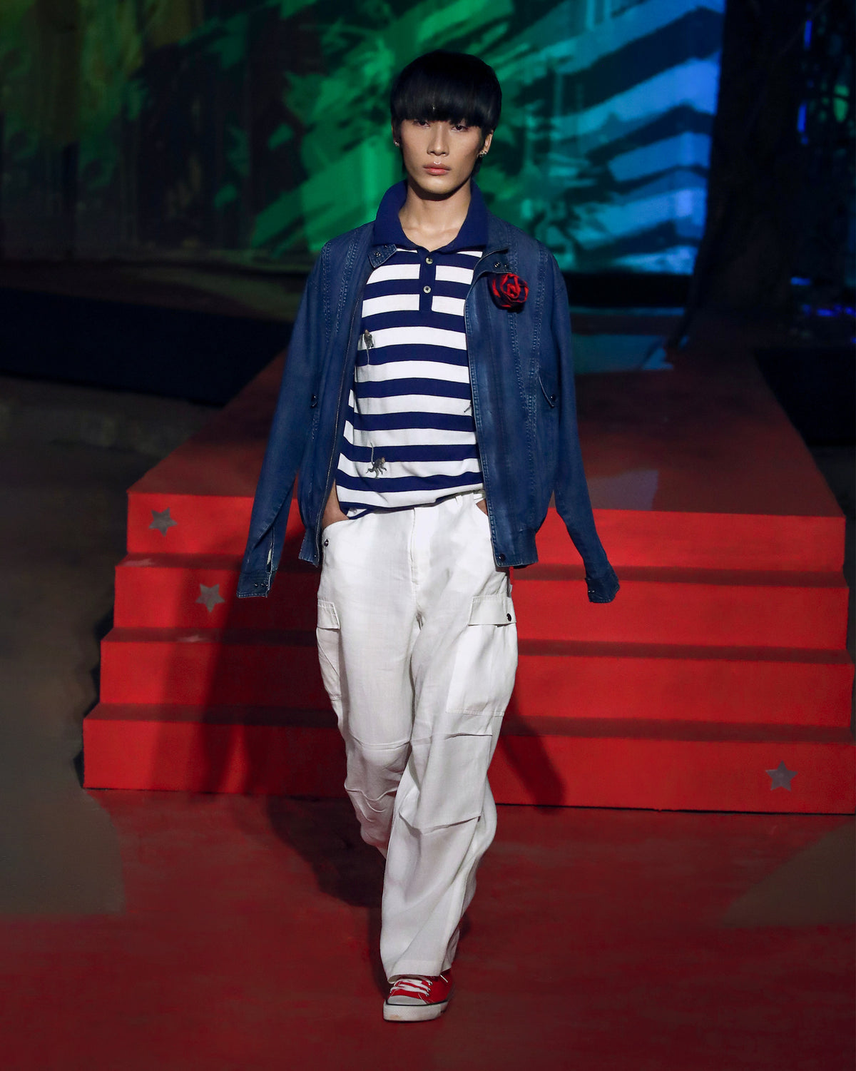 Navy-and-white striped polo with embroidered macaques worn on a runway.