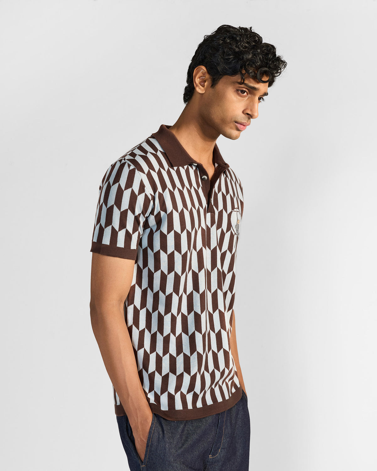 Side view of a brown and light grey geometric Langur polo worn by a person.