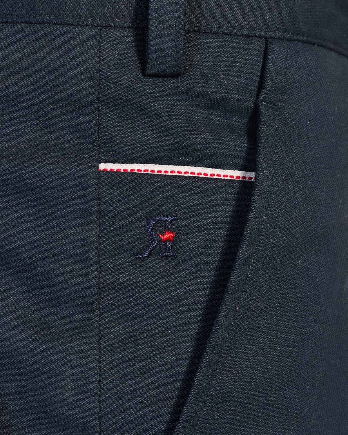 Close-up of a navy Flycatcher Trousers pocket with red trim and R embroidery.