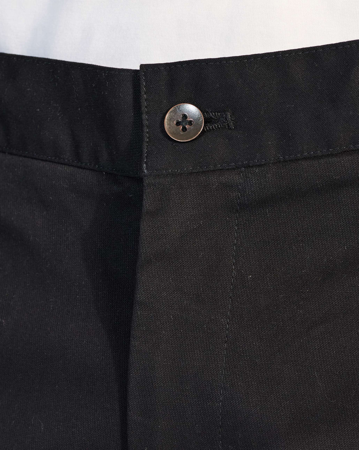 Close-up of the waistband button and fly on black Panther Trousers.