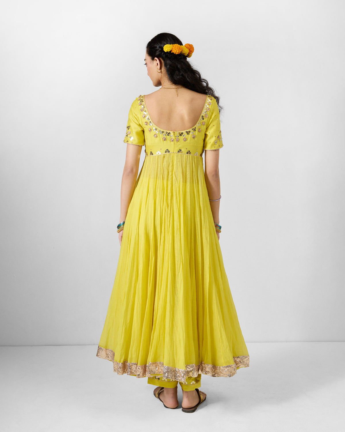 Back of a yellow Cherai kurta with a deep open neckline and gold gota embroidery.