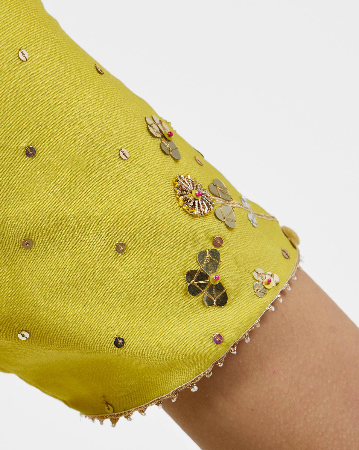 Close-up of a yellow Cherai kurta sleeve with gold sequin florals and a beaded cuff.