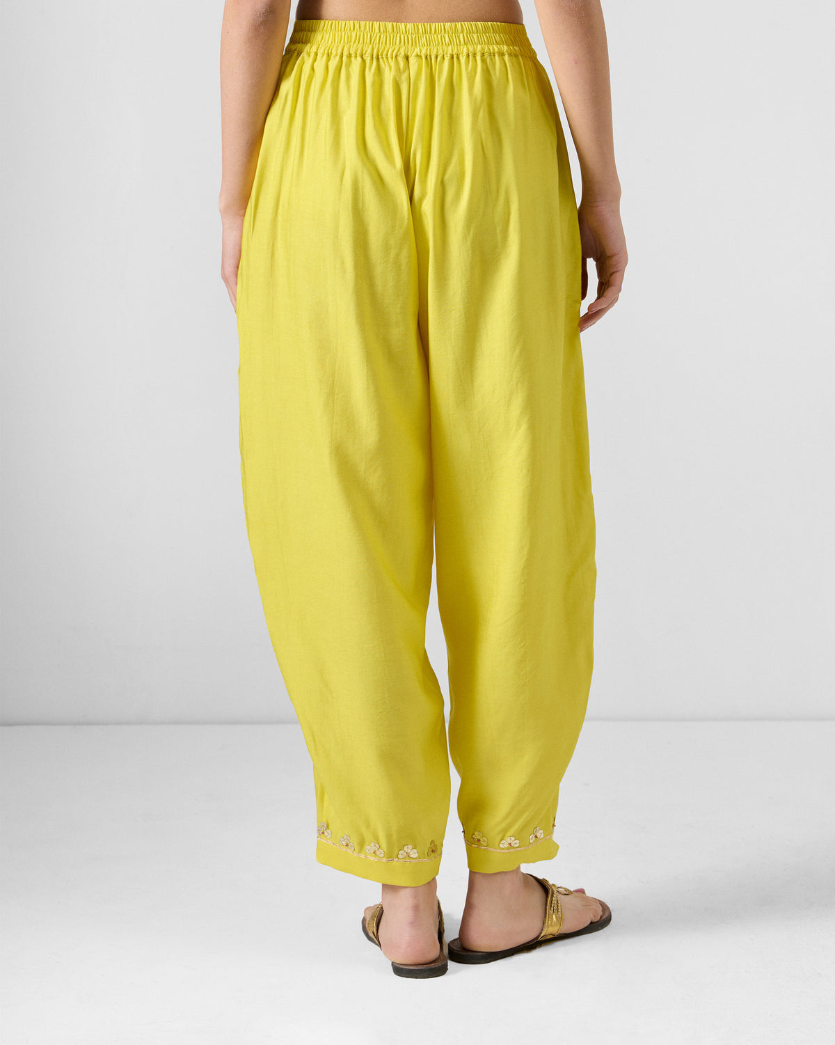 Back of yellow Lebong pants with a gathered waist and gold hems.