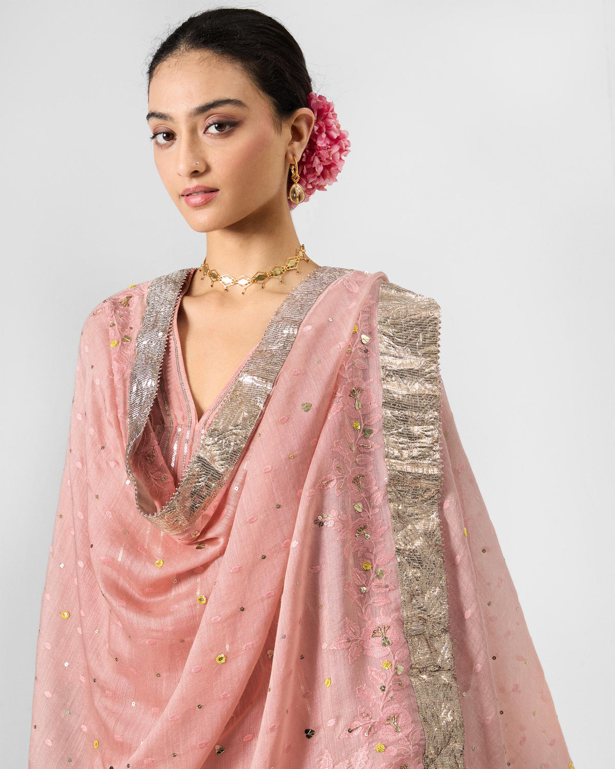 Person wearing a dust pink embroidered Lila dupatta with a silver gota border.