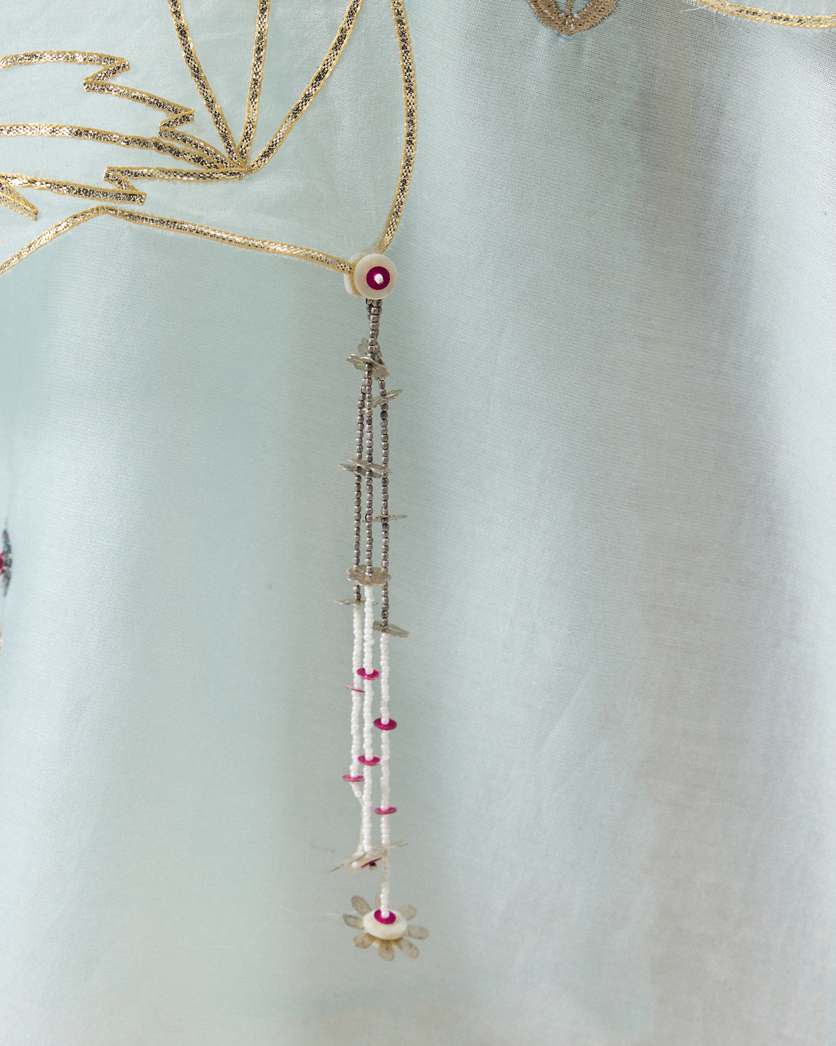 Close-up of a powder blue Kasara Dupatta showing a beaded corner tassel.