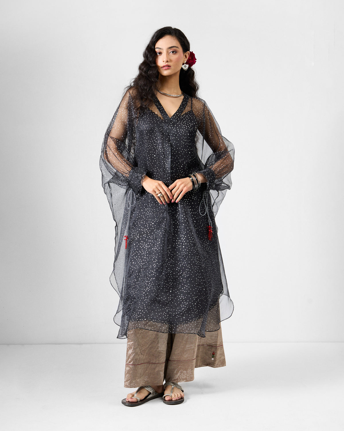 Charcoal Amboli Kaftan with foiled stars and red tassels at the sleeves.