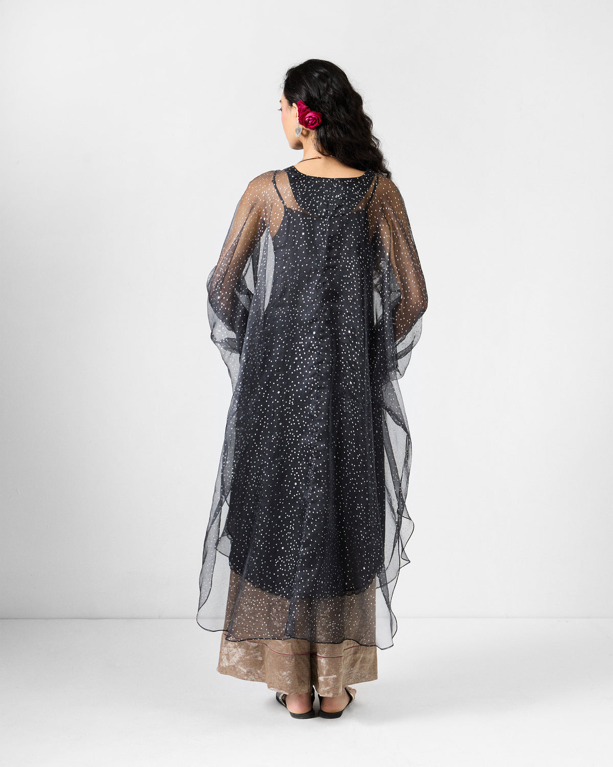 Back of a sheer charcoal Amboli Kaftan with foiled star detailing.