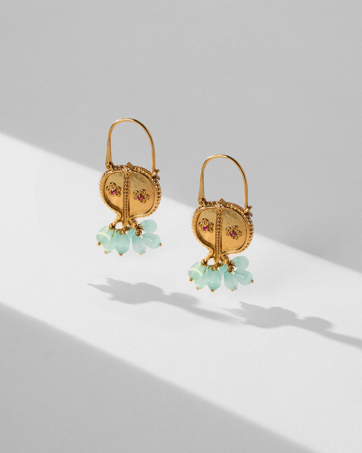 Pair of gold Anaar balis with red floral stones and pale turquoise bead drops.