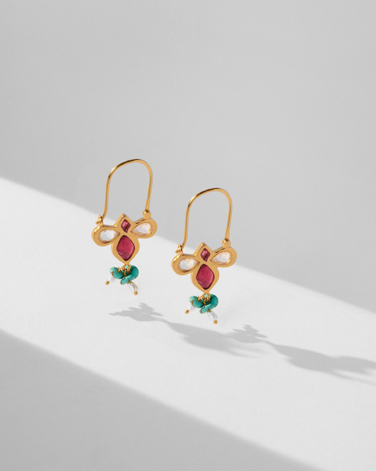 Gold doli earrings showing trefoil glass setting and bead tassels.