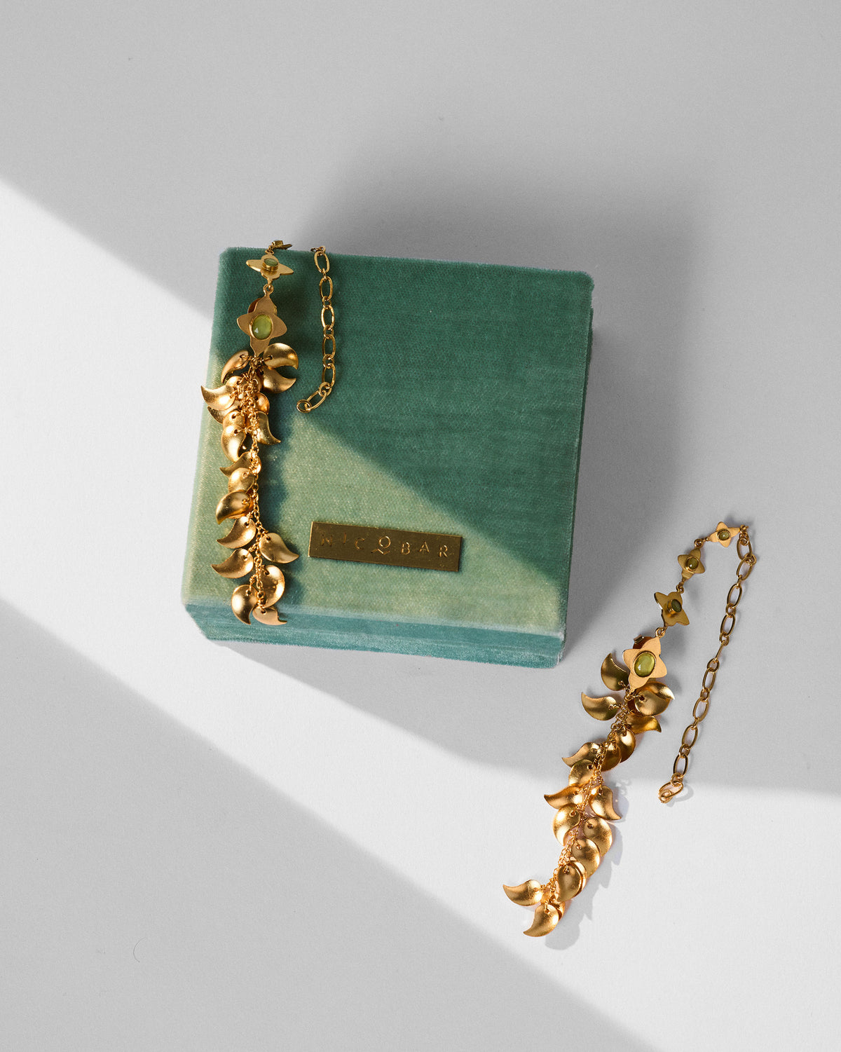 Pair of Kairi Earrings resting on a green velvet box.