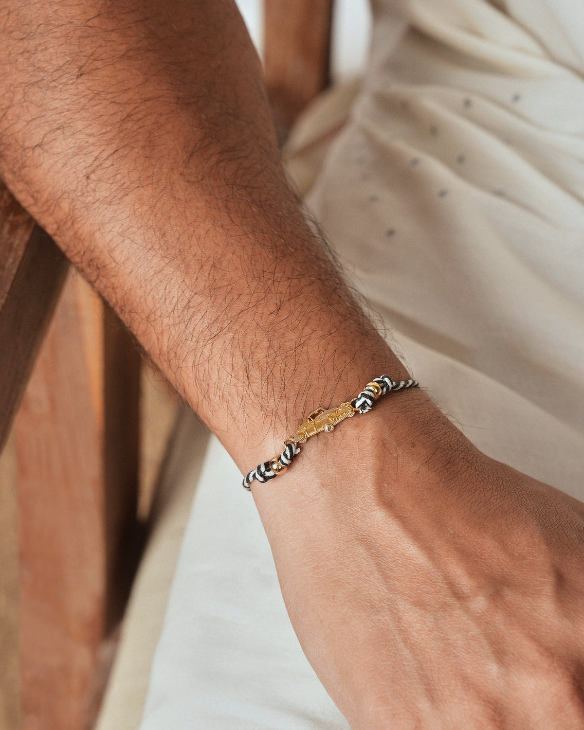 Person wearing a Vintage Car Rakhi with a gold car charm on the wrist.