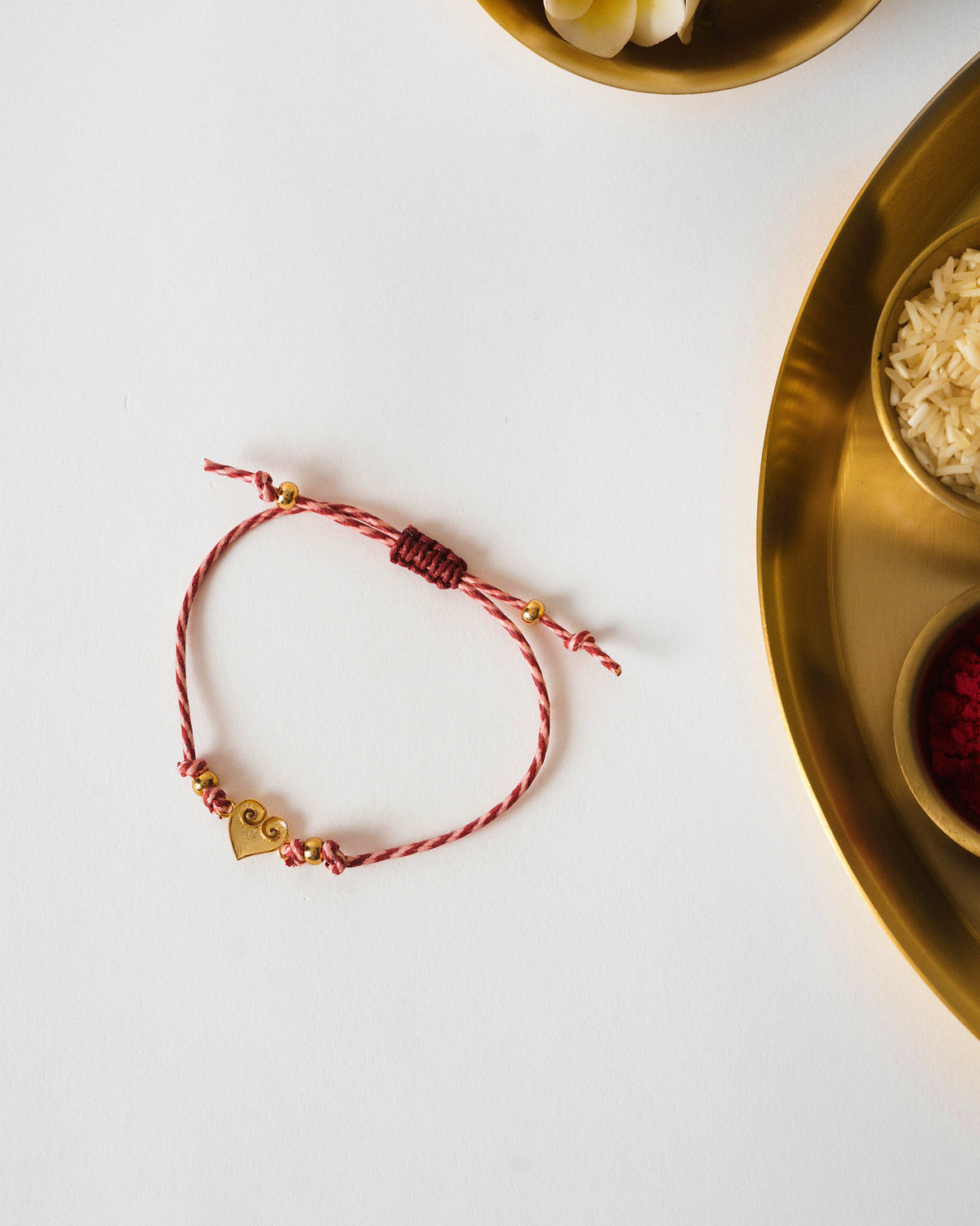 Dil Rakhi in red and white stripes laid on a white surface.