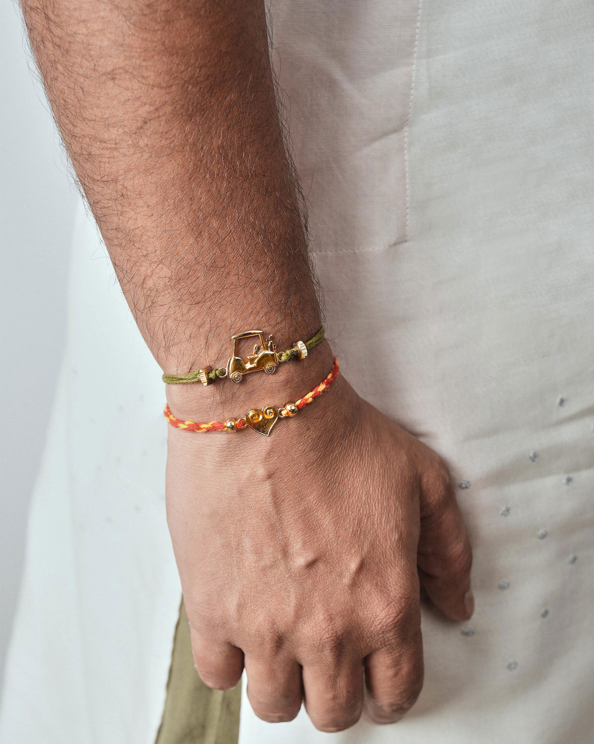 Person wearing a Dil Rakhi with a gold heart charm on the wrist.