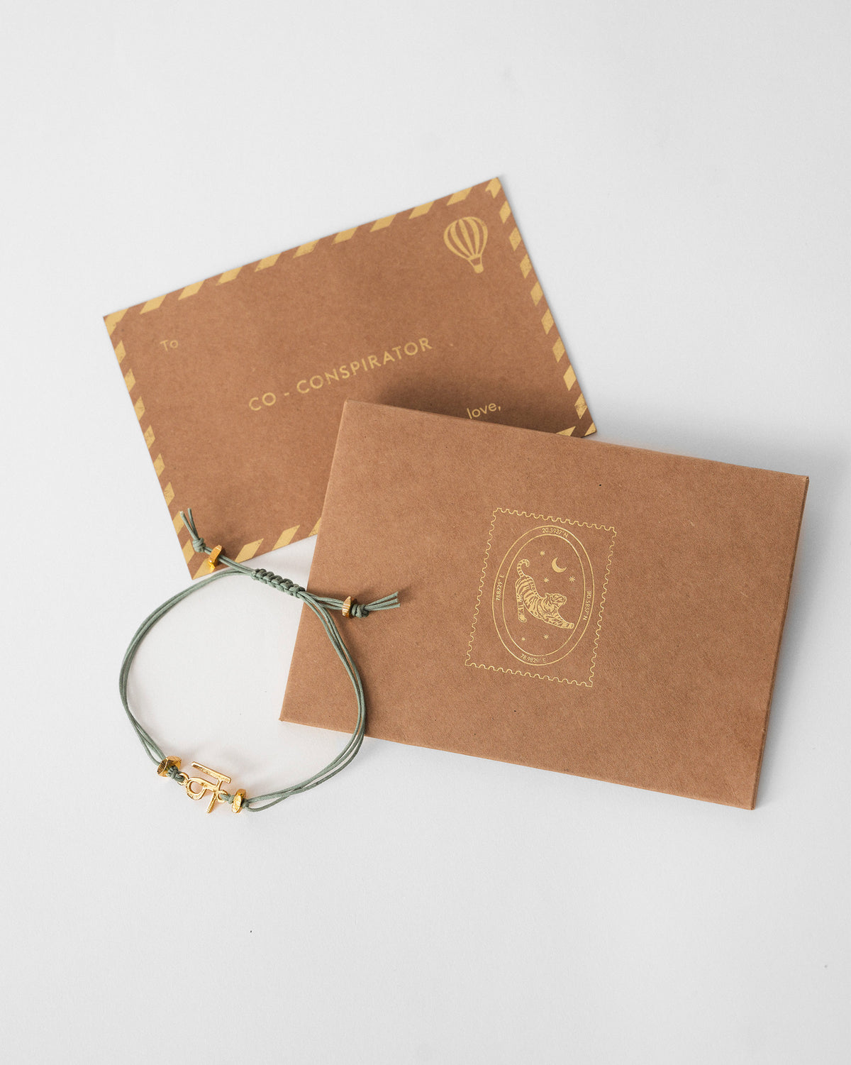 Alphabet N Rakhi beside a kraft envelope and card.
