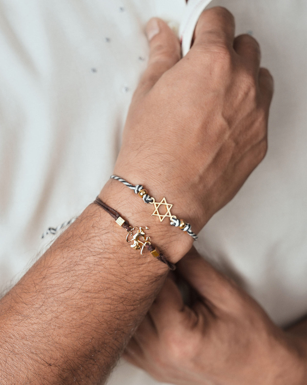 Person wearing a brown Monkey Rakhi with a gold charm.