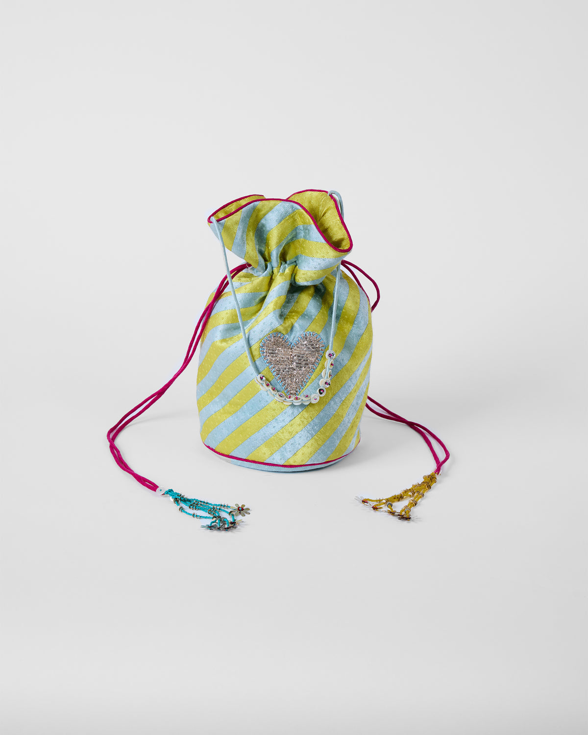Full view of an ice blue and yellow striped potli with sequin heart and tassels.
