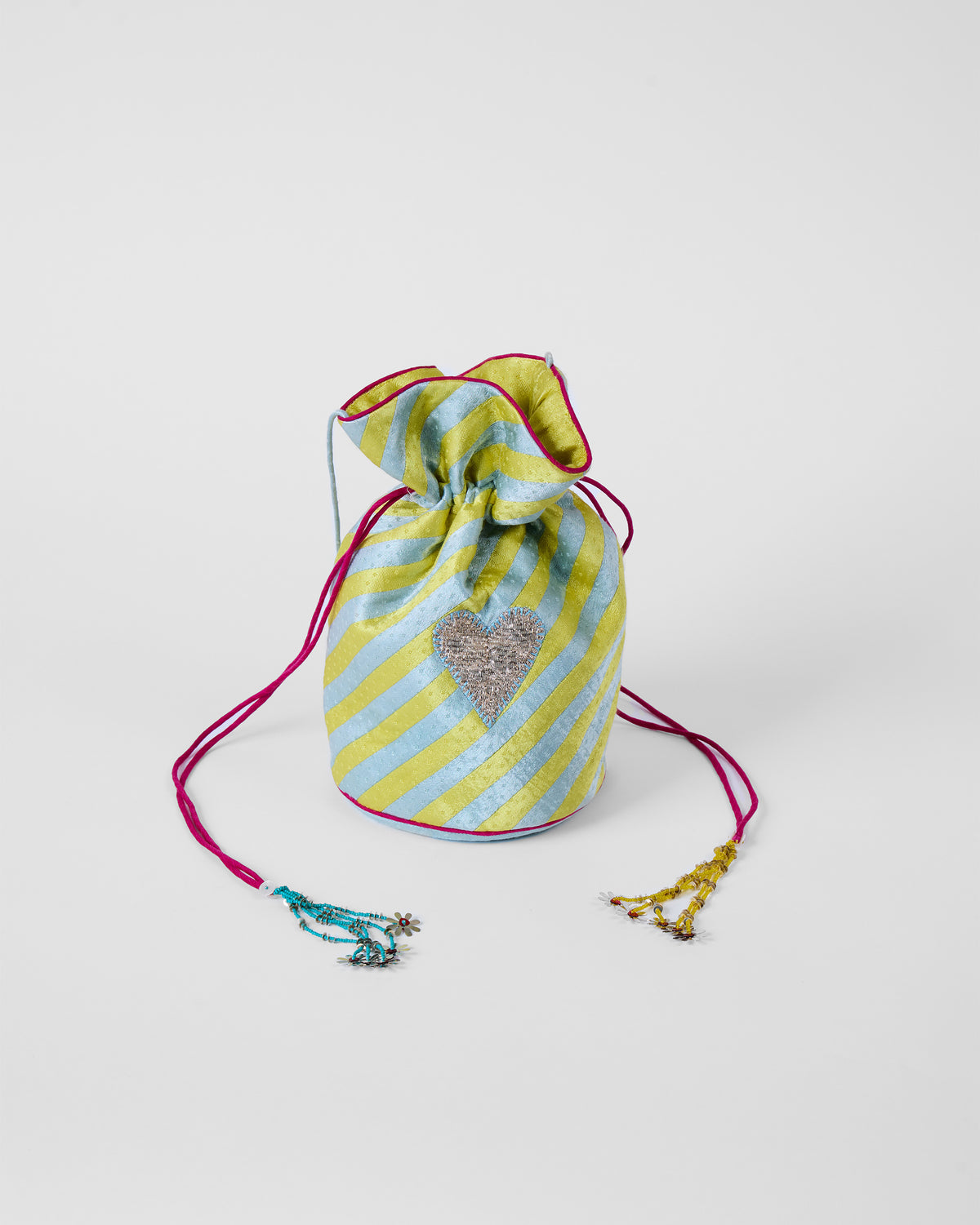 Ice blue and yellow striped potli standing upright with a silver heart motif.