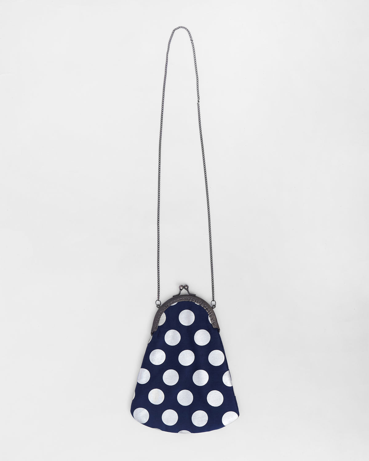 Dottie Clutch in navy with white polka dots and a long chain strap.
