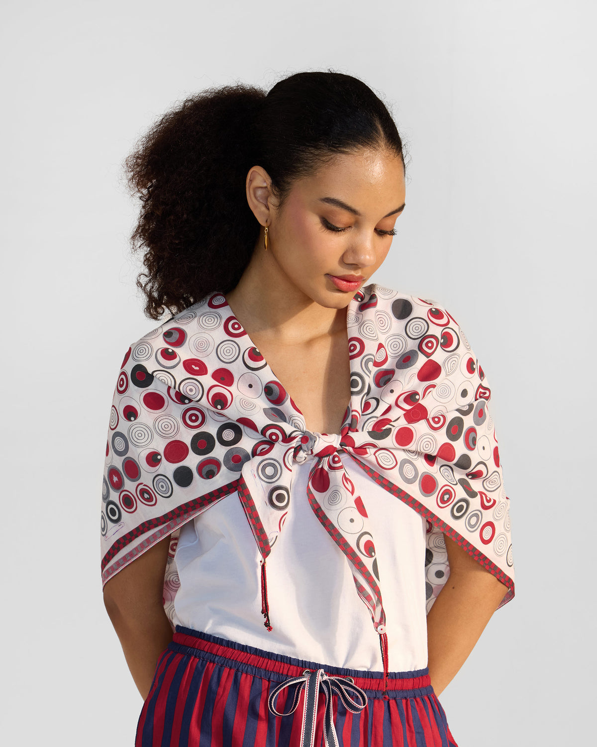 Person wearing a red and grey Ripple scarf with a concentric circle print.