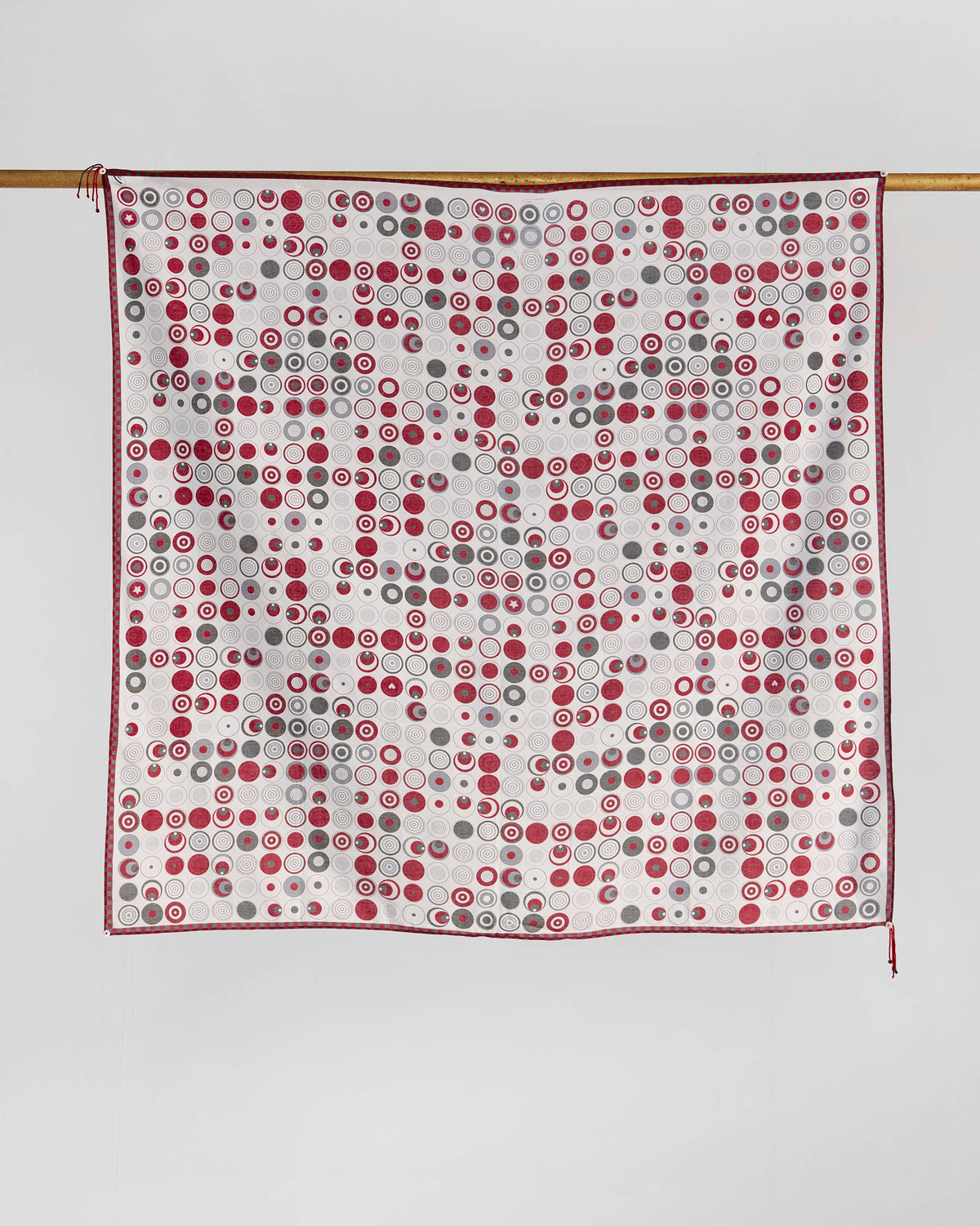 Ripple scarf hung flat, showing a red and grey circle pattern on white.