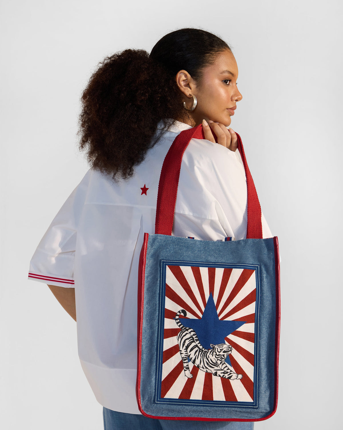 Person carrying a blue Nico Matchbox tote with a tiger stamp.