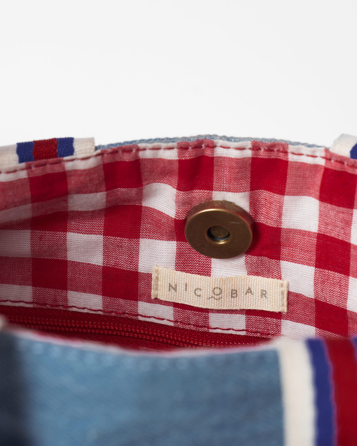 Interior of a Nico Matchbox tote with a red gingham lining.