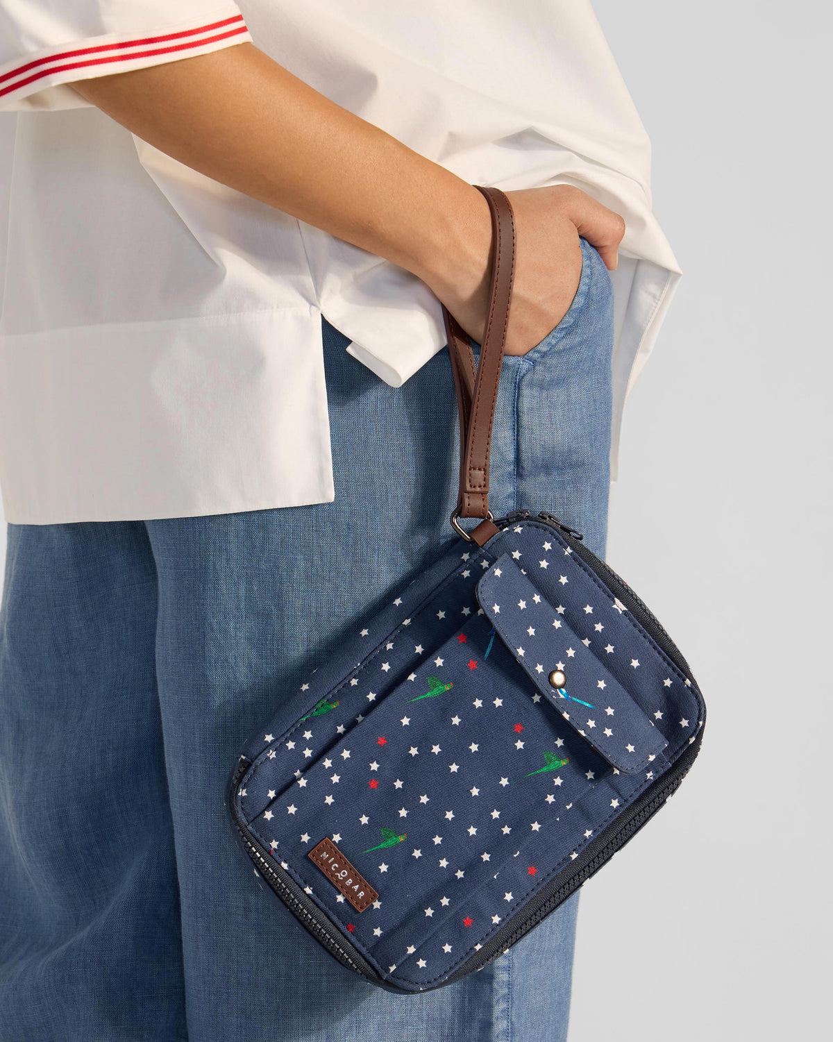 Navy Gadget Pouch with stars and green parrots worn on a wrist strap.