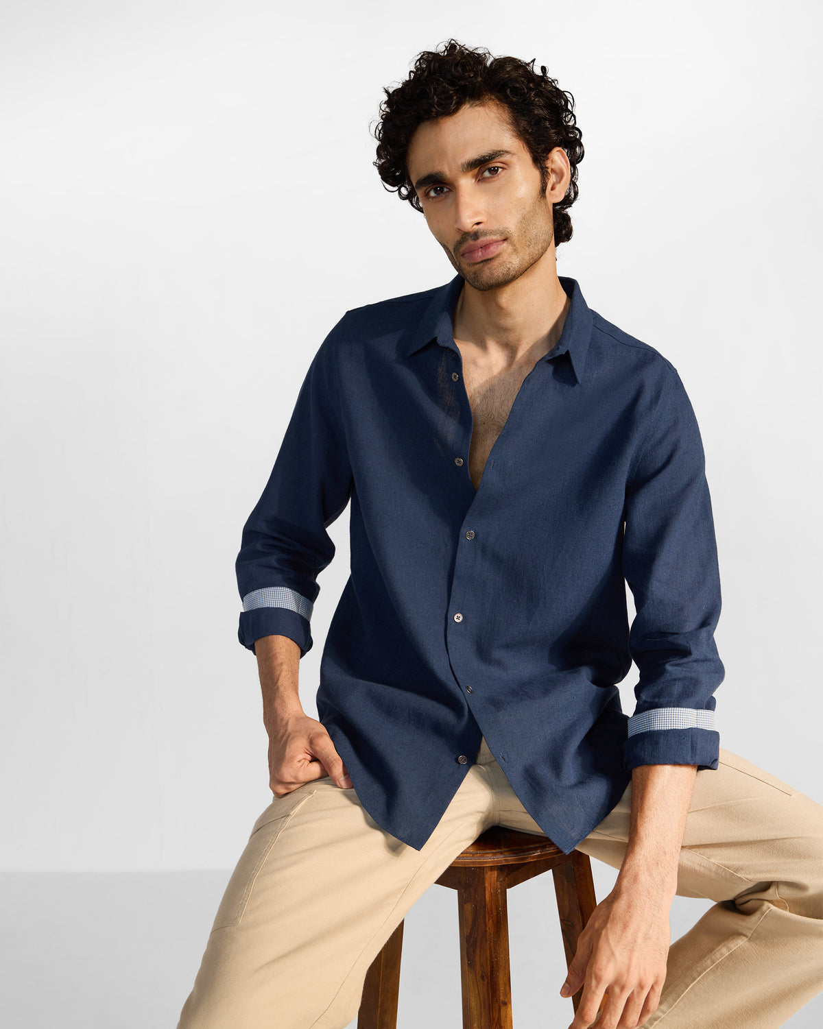 Person wearing a navy Rewa shirt with contrasting cuff lining.